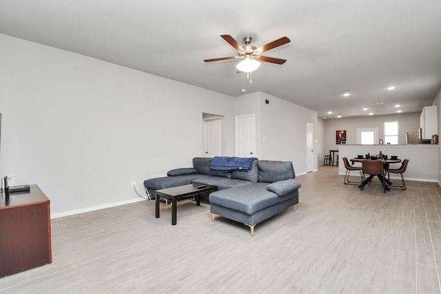 living room with light hardwood / wood-style flooring and ceiling fan