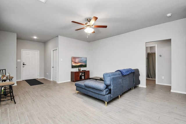 living room with ceiling fan and light hardwood / wood-style flooring