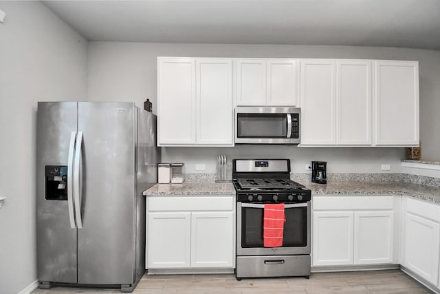 kitchen featuring white cabinetry, appliances with stainless steel finishes, and light stone countertops