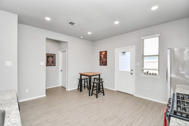 interior space with light stone counters, stainless steel appliances, and light wood-type flooring