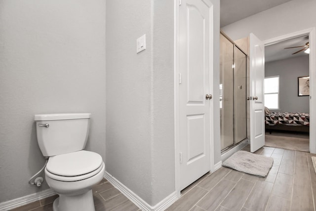 bathroom featuring an enclosed shower, ceiling fan, and toilet