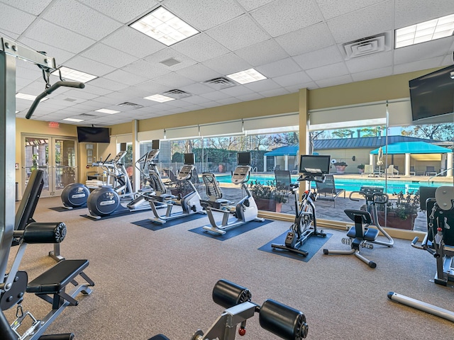 workout area with a healthy amount of sunlight and a drop ceiling