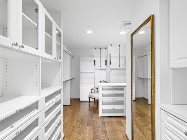 spacious closet with dark hardwood / wood-style flooring