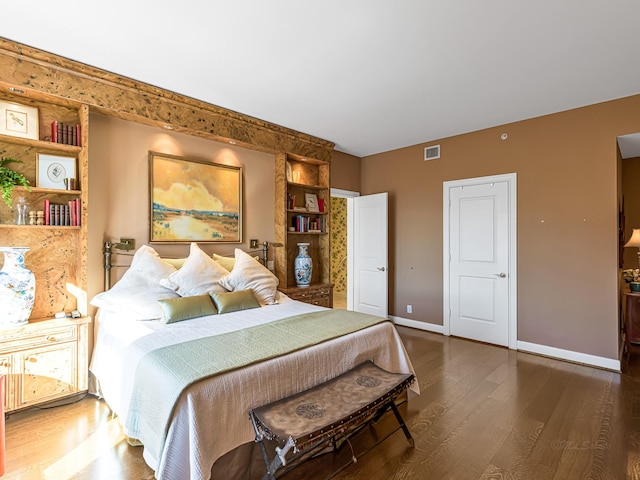 bedroom with dark hardwood / wood-style floors