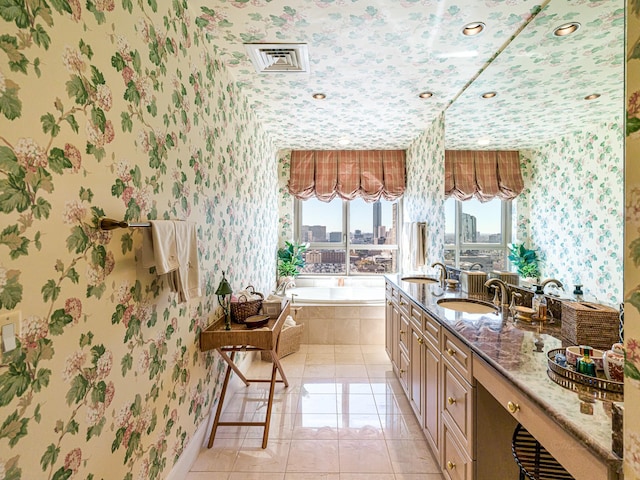 bathroom with vanity, a relaxing tiled tub, and tile patterned floors