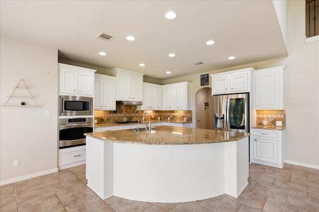 kitchen featuring stainless steel appliances, white cabinetry, and a center island with sink