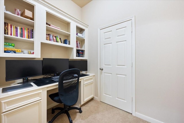 office featuring built in desk and light colored carpet