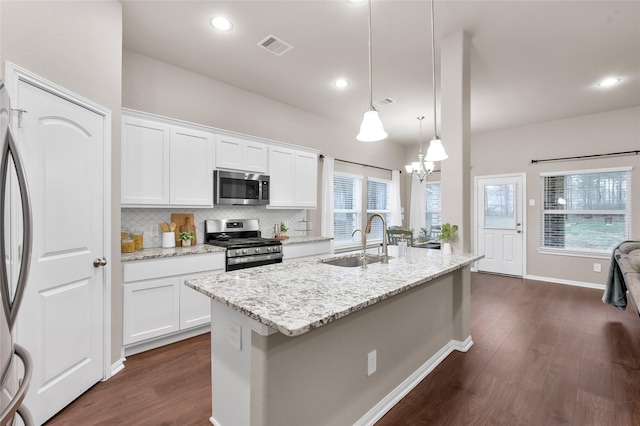 kitchen with pendant lighting, white cabinetry, stainless steel appliances, and sink