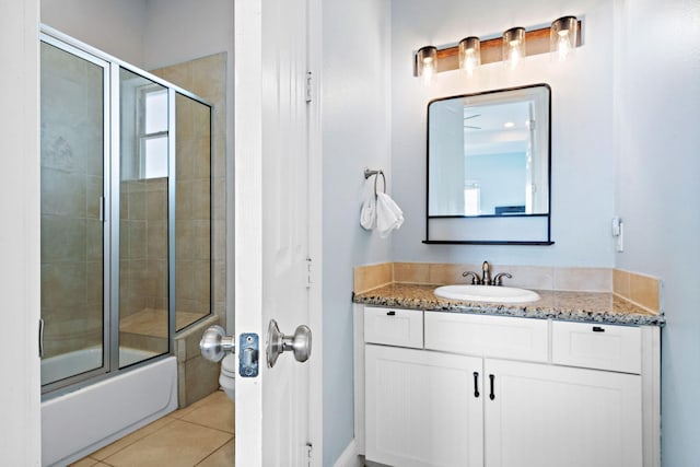 full bathroom featuring toilet, vanity, shower / bath combination with glass door, and tile patterned flooring