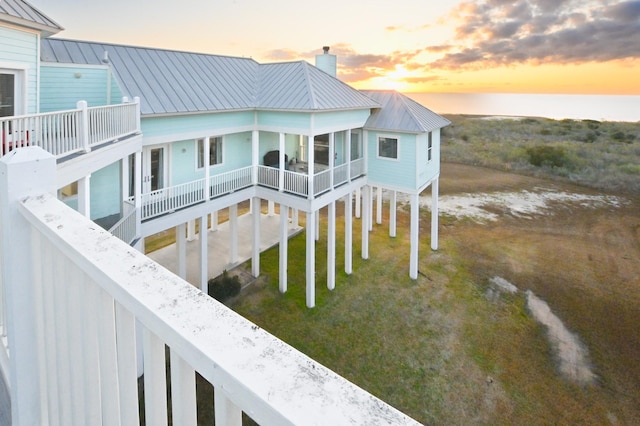 back house at dusk featuring a balcony