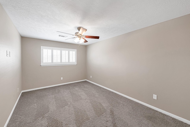 spare room with a textured ceiling, ceiling fan, and carpet