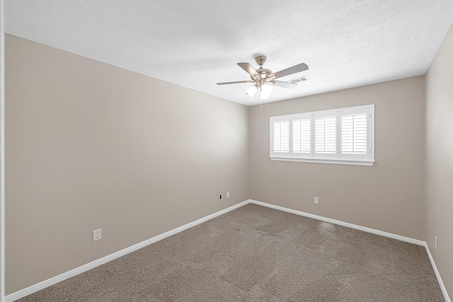 carpeted spare room with a textured ceiling and ceiling fan