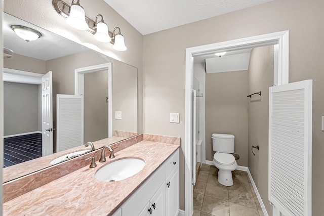 bathroom featuring vanity, toilet, and tile patterned flooring