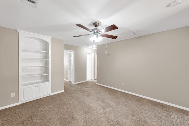 unfurnished room with built in shelves, ceiling fan, and carpet floors