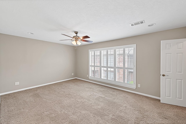 unfurnished room with ceiling fan, carpet, and a textured ceiling