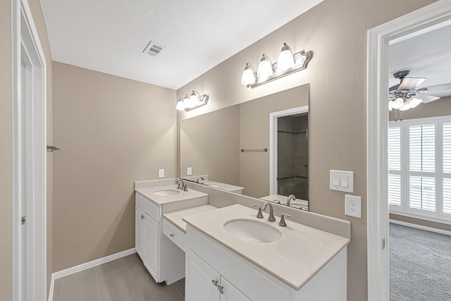 bathroom with vanity, ceiling fan, tile patterned floors, and a textured ceiling