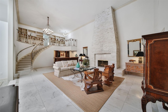 living area with a notable chandelier, a high ceiling, a fireplace, stairs, and ornamental molding