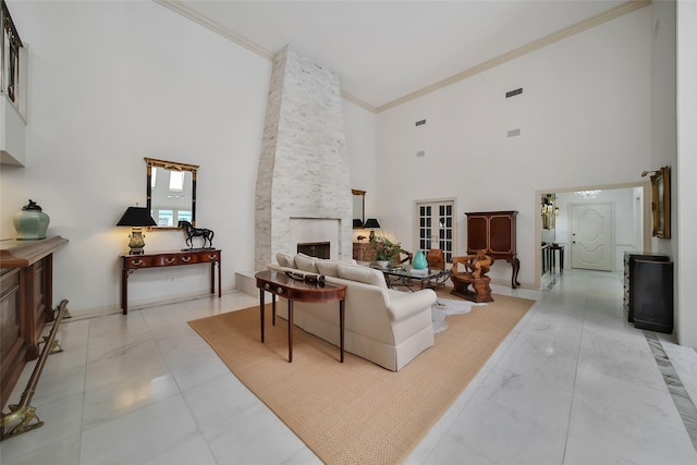 living area featuring baseboards, a high ceiling, a fireplace, and crown molding