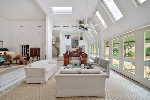 living room with a skylight, visible vents, high vaulted ceiling, and a ceiling fan