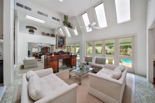 carpeted living area with high vaulted ceiling, visible vents, and ceiling fan with notable chandelier