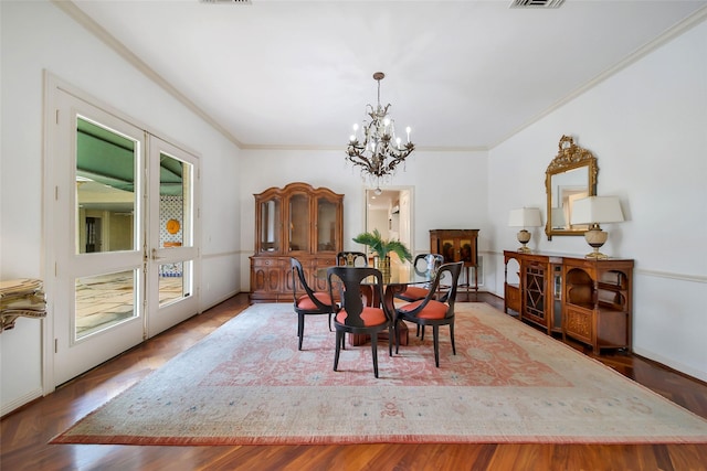 dining space featuring ornamental molding, visible vents, and an inviting chandelier