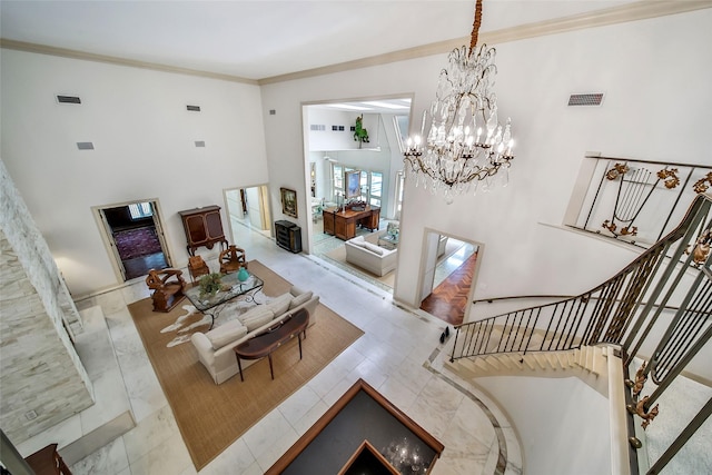 living room featuring a chandelier, a high ceiling, visible vents, ornamental molding, and stairway