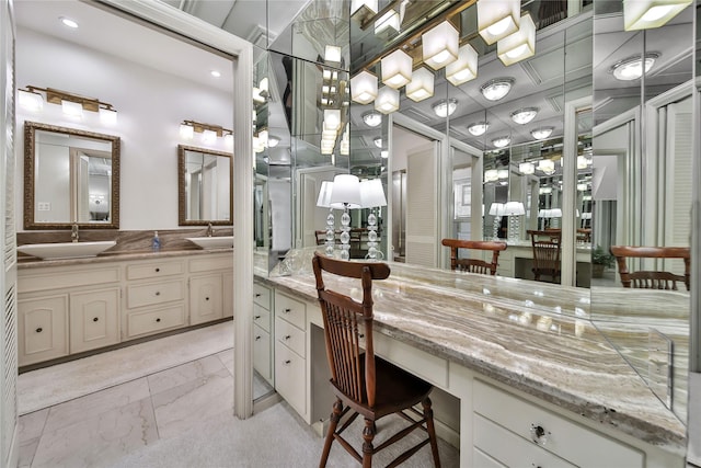 bathroom with double vanity, marble finish floor, and a sink