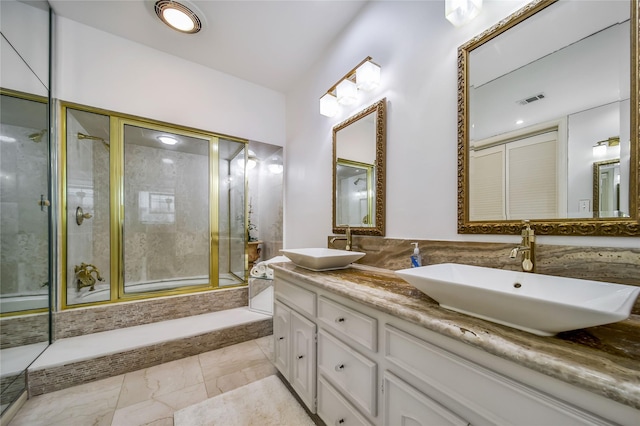 full bathroom featuring a shower with shower door, marble finish floor, visible vents, and a sink