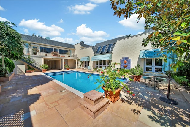 outdoor pool featuring a patio area and french doors