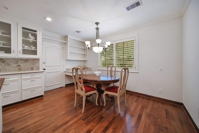 dining room with baseboards, dark wood finished floors, visible vents, and an inviting chandelier