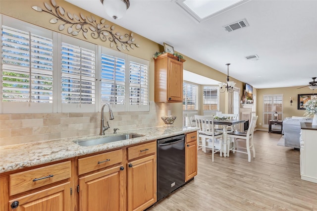 kitchen with tasteful backsplash, visible vents, dishwasher, light wood-type flooring, and a sink