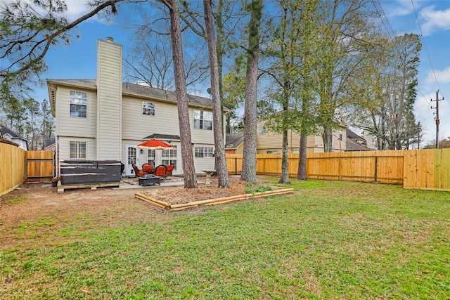 back of house featuring a yard, a fenced backyard, and a chimney