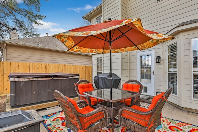 view of patio / terrace with outdoor dining area, fence, a grill, and a hot tub