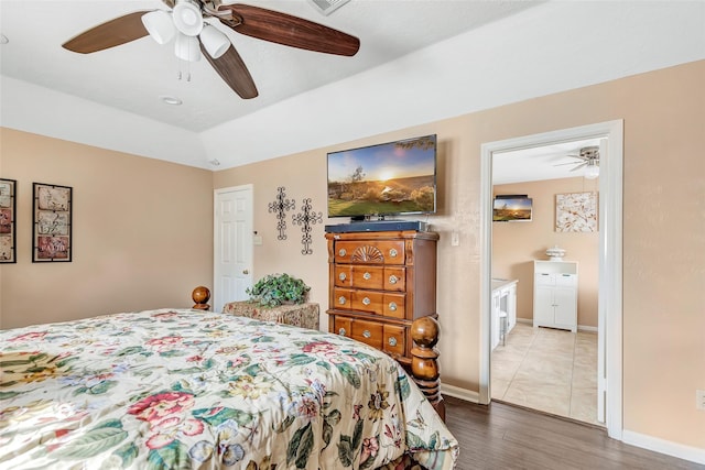 bedroom featuring baseboards, wood finished floors, and a ceiling fan