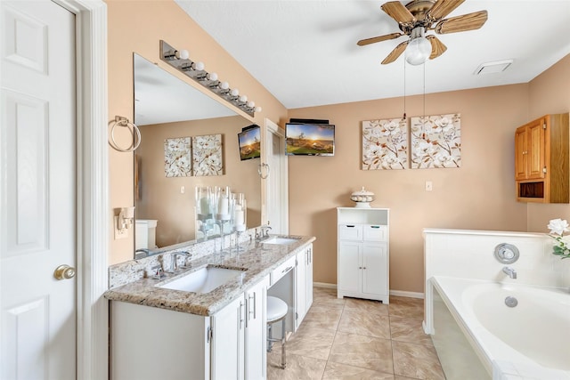 full bath featuring a bath, double vanity, ceiling fan, and a sink