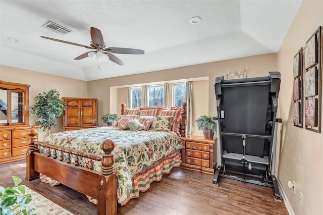 bedroom with wood finished floors, baseboards, visible vents, lofted ceiling, and ceiling fan