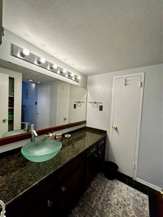 bathroom with vanity, tile patterned floors, and a textured ceiling