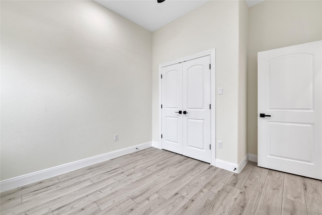 unfurnished bedroom with light hardwood / wood-style floors and a closet