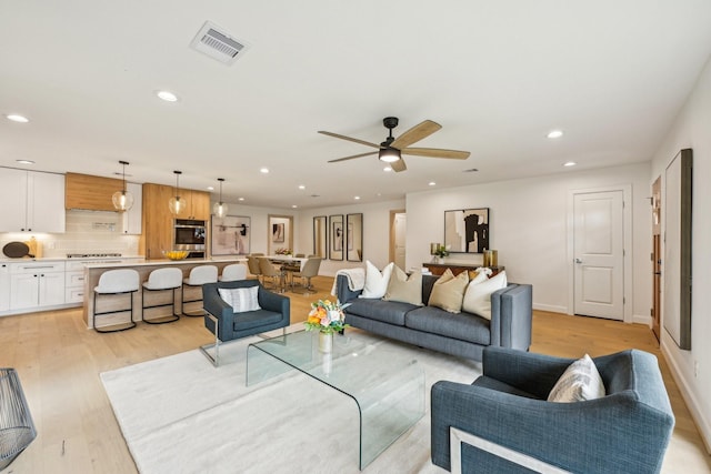 living room featuring light hardwood / wood-style floors and ceiling fan