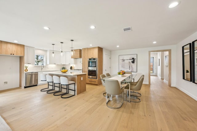 dining area featuring sink and light hardwood / wood-style flooring