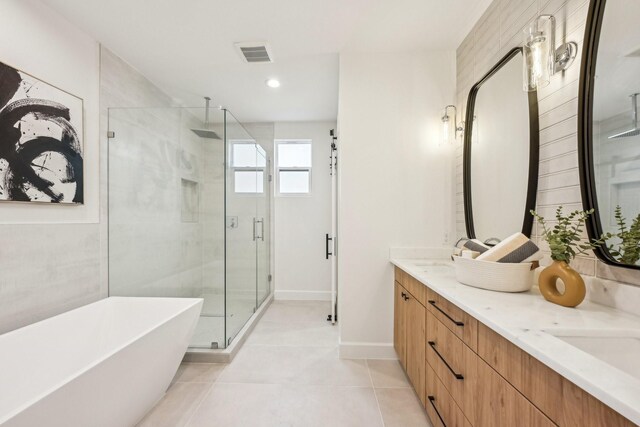 bathroom with tile patterned floors, shower with separate bathtub, and vanity