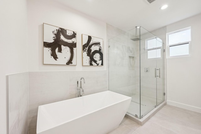 bathroom with tile patterned floors, independent shower and bath, and tile walls