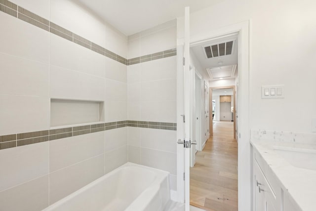 bathroom with vanity, hardwood / wood-style floors, and a tub