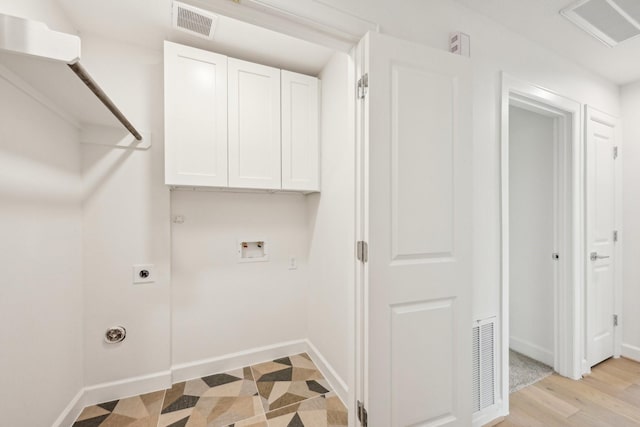 clothes washing area featuring cabinets, electric dryer hookup, washer hookup, and hookup for a gas dryer