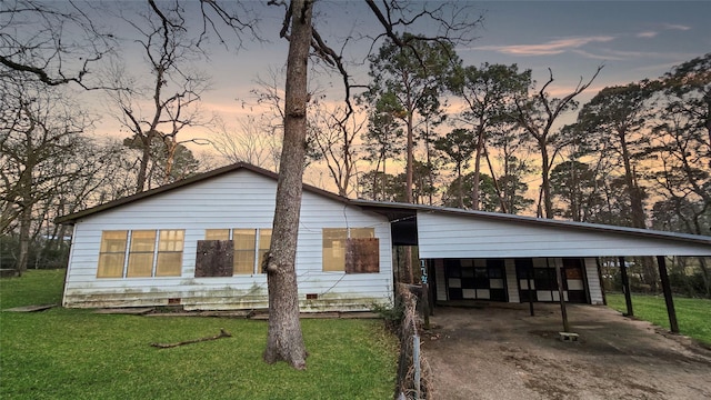 view of front of home featuring a carport and a yard