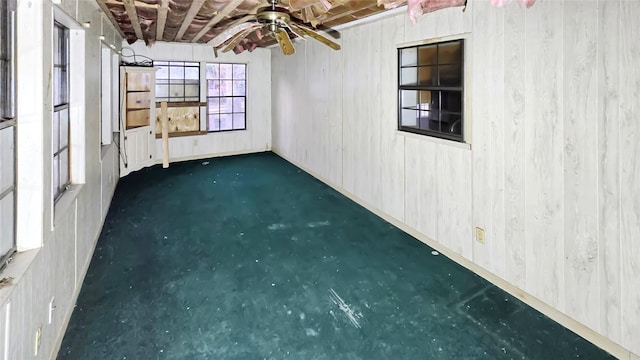 unfurnished room featuring ceiling fan and dark colored carpet