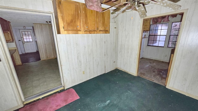 empty room featuring wooden walls and ceiling fan