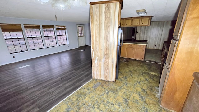 kitchen with black refrigerator and dark hardwood / wood-style flooring