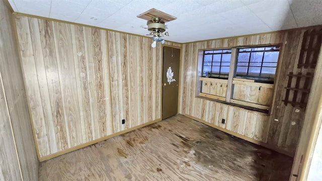 spare room featuring wood-type flooring and wood walls