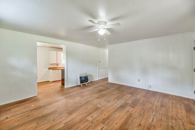 unfurnished living room featuring ceiling fan, heating unit, and light hardwood / wood-style flooring